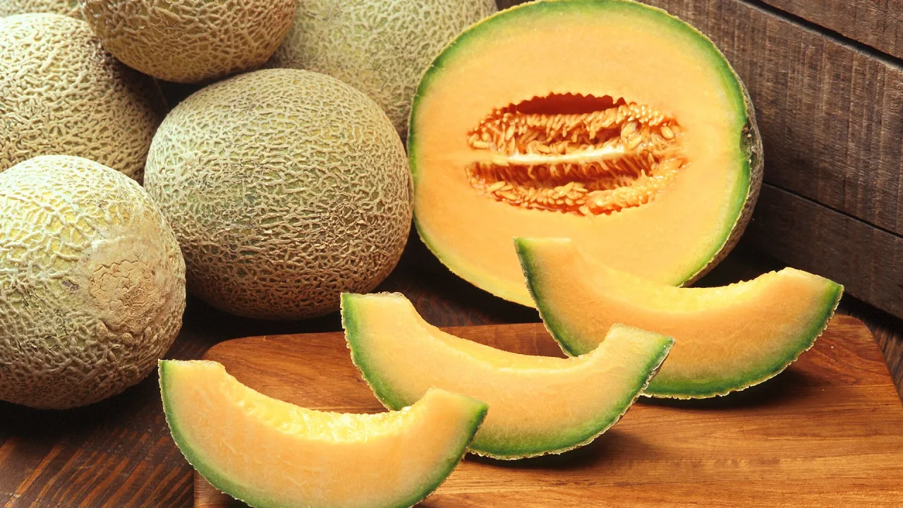 Hela och skivade meloner med orange fruktkött